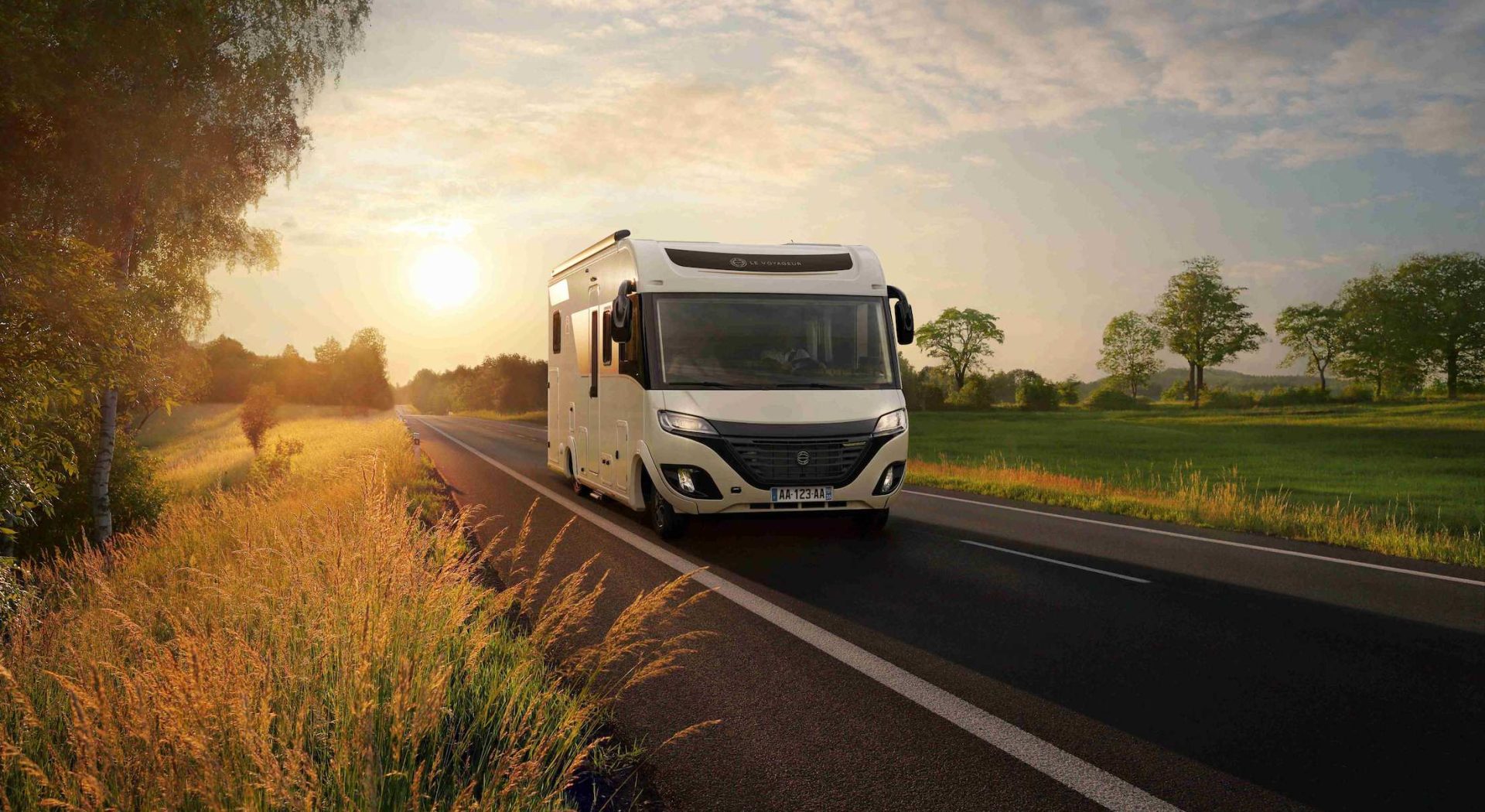 camping car le voyageur avec un coucher de soleil sur la route