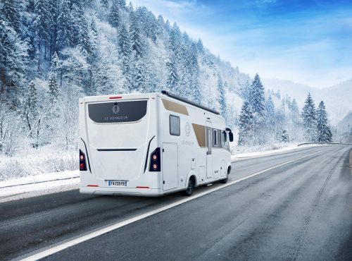 camping car le voyageur roulant sur une route enneigée